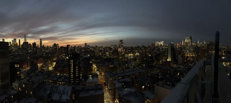 The Manhattan skyline at dusk from a rooftop, from One World Trade Center on the left to the Empire State Building on the right.